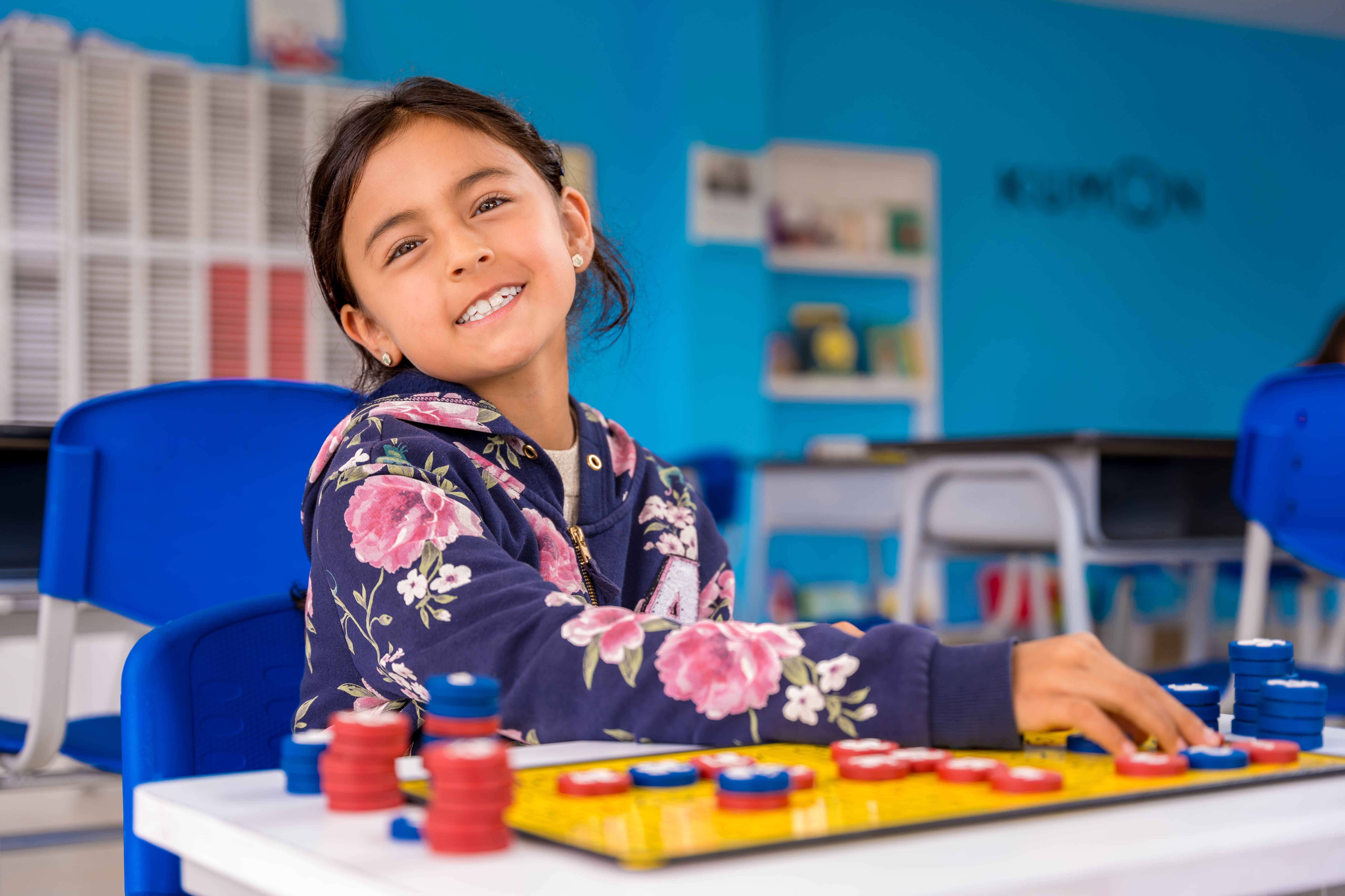 Niña estudiando matemáticas básicas con tablero magnético en un centro Kumon, disfrutando del aprendizaje-Peru