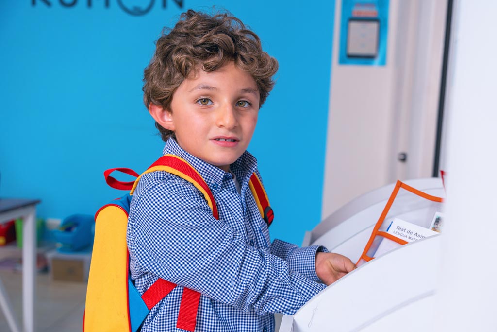 Niño entregando sus tareas en un centro Kumon, listo para continuar su aprendizaje con el método individualizado-Peru