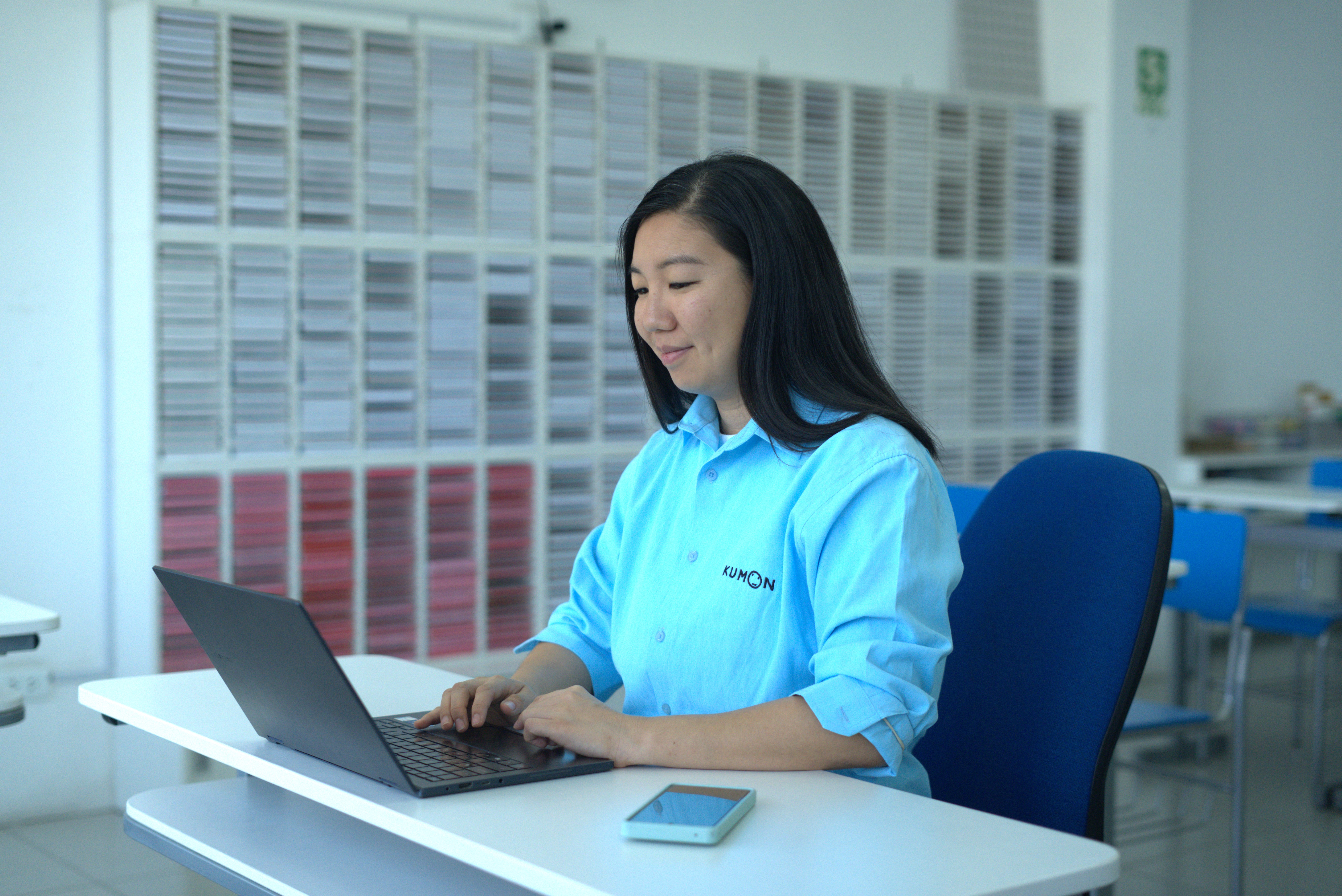 Orientador de Kumon frente a una computadora, participando en una capacitación en línea
