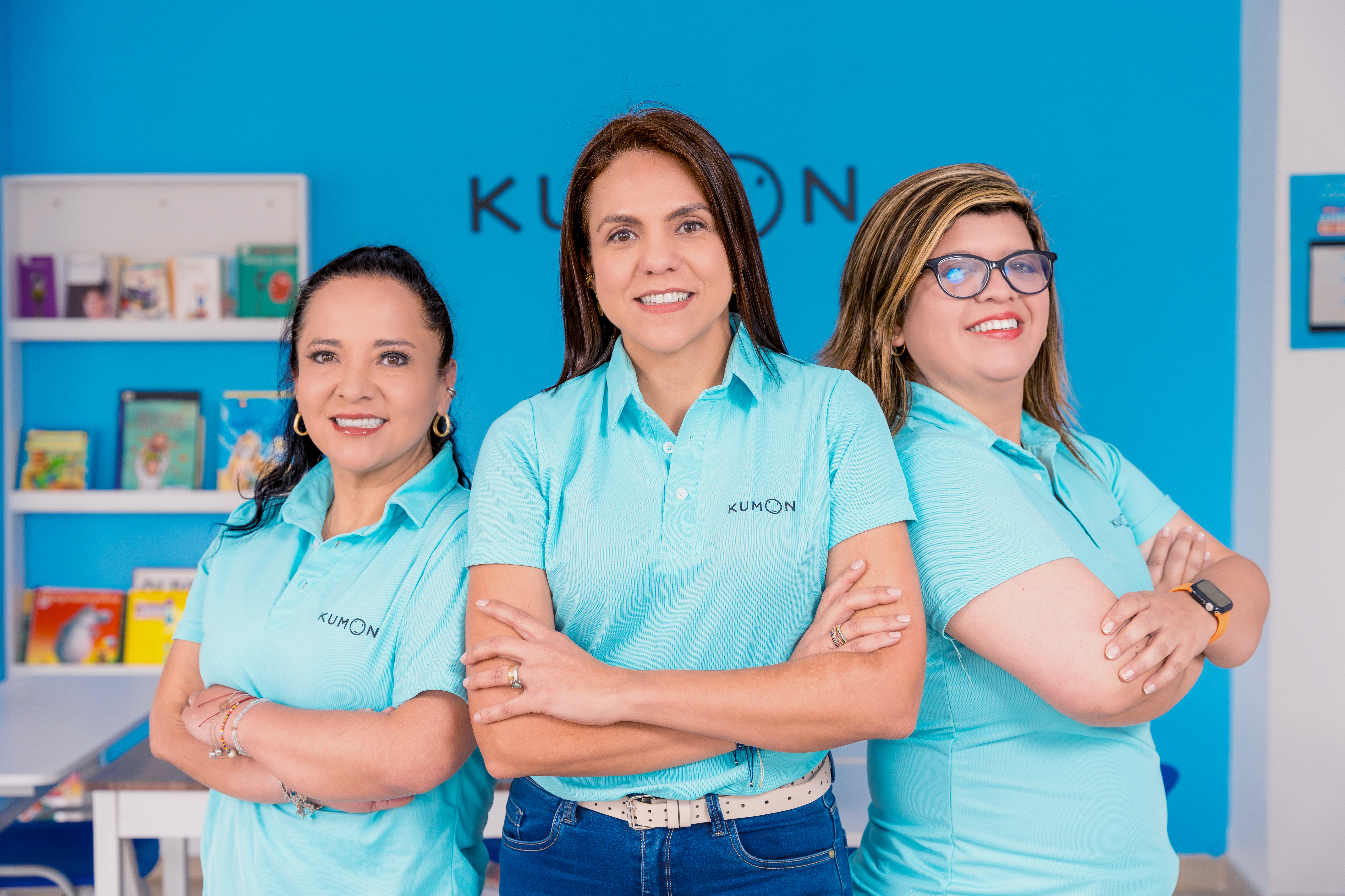 Tres orientadores de Kumon de éxito, con los brazos cruzados, una sonrisa y postura de emprendedores